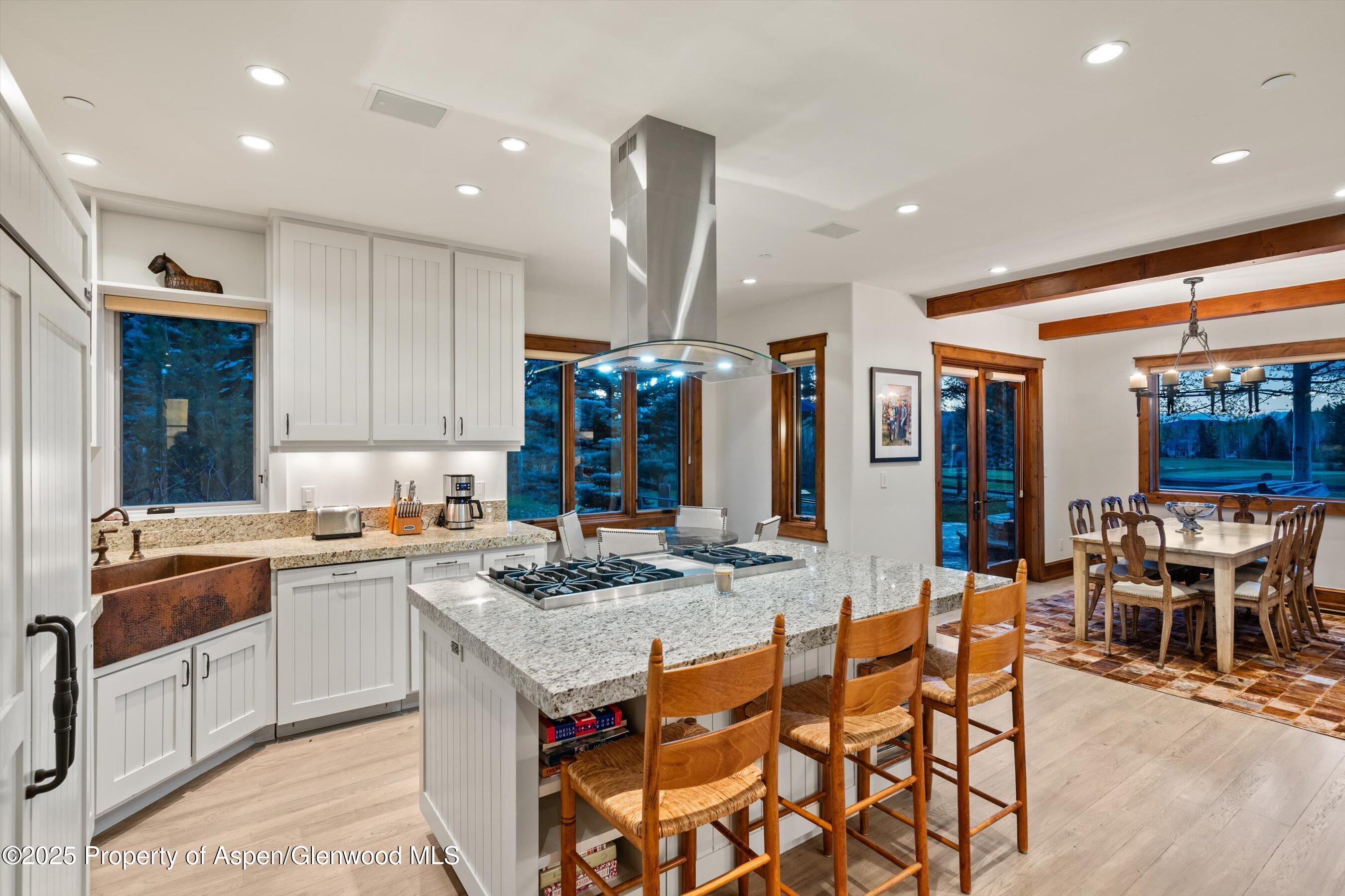 1430 Sierra Vista Drive Aspen, CO 81611 - Photo 10 of 57 a kitchen with stainless steel appliances granite countertop a stove top oven a sink a dining table and chairs with wooden floor