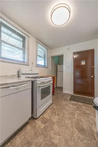 a kitchen with a stove cabinets and window