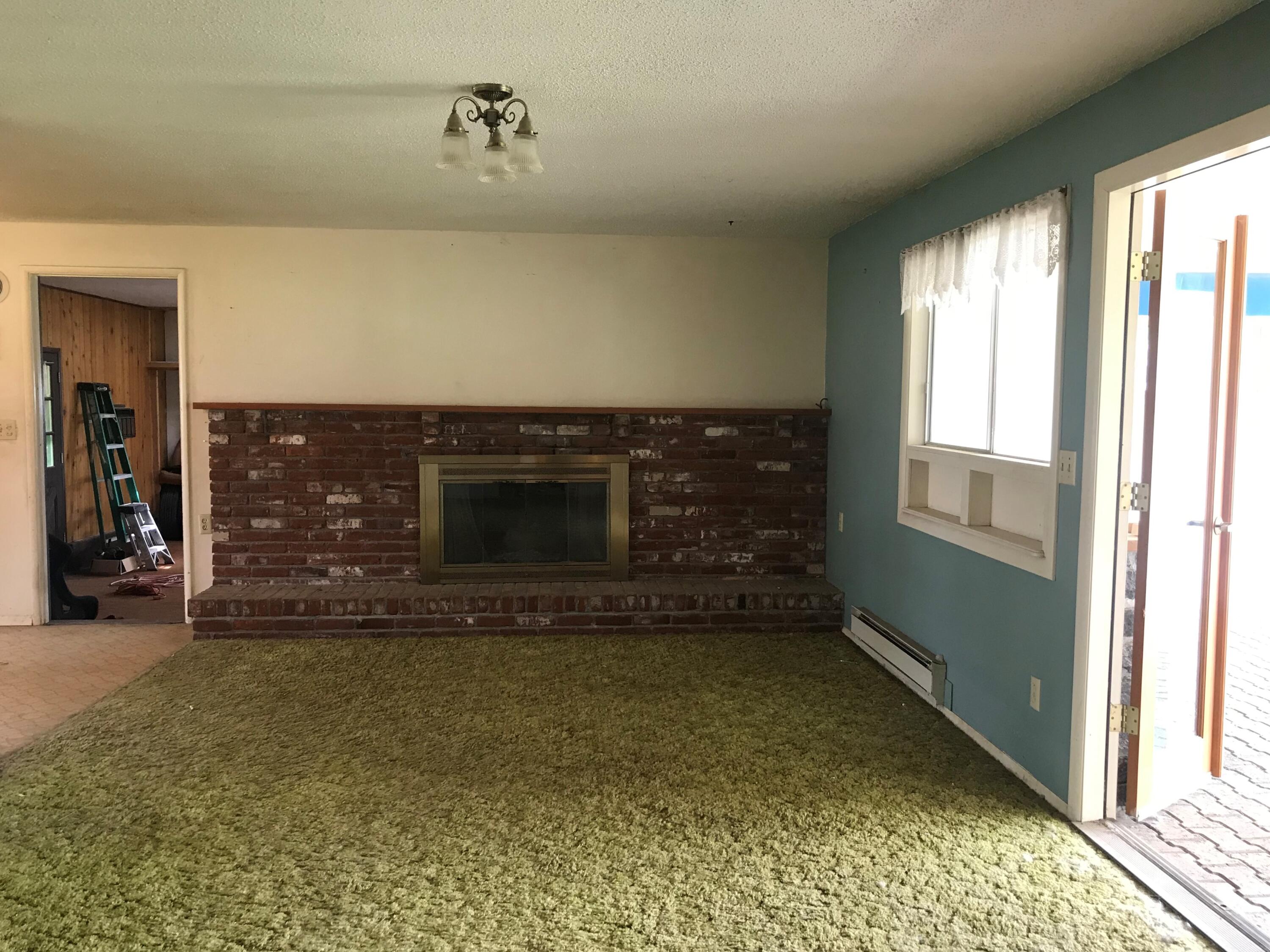22980 McGrath Road Bend, OR 97701 - Photo 13 of 23 a view of an empty room with a fireplace and a window