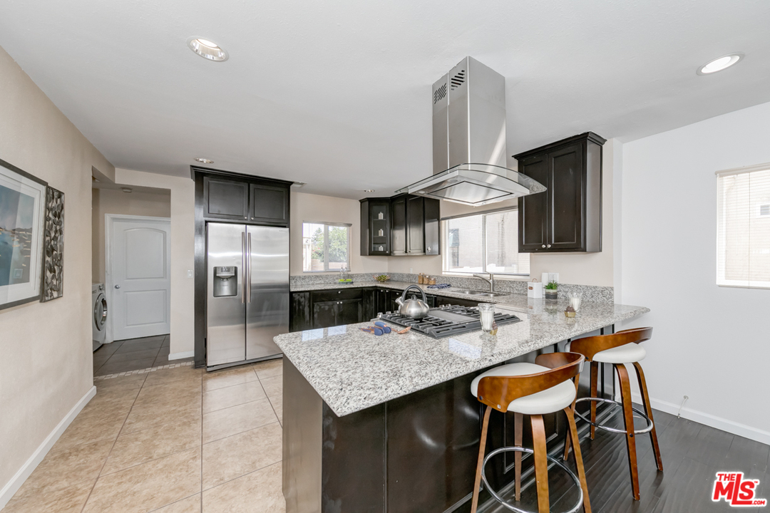 2816 Virginia Road Los Angeles, CA 90016 - Photo 8 of 29 a kitchen with stainless steel appliances granite countertop a stove refrigerator and cabinets