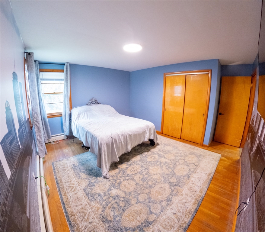 25 A White Avenue Worcester, MA 01605 - Photo 12 of 13 a bedroom with a bed and wooden floor