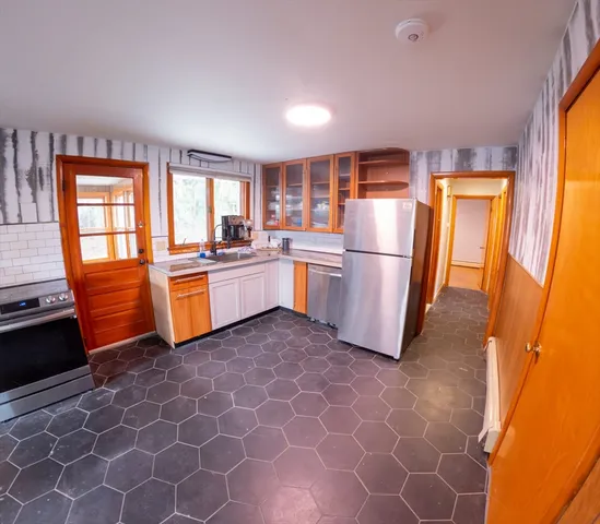 a kitchen with stainless steel appliances granite countertop a refrigerator and a stove top oven