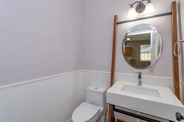 a bathroom with a toilet a sink and mirror