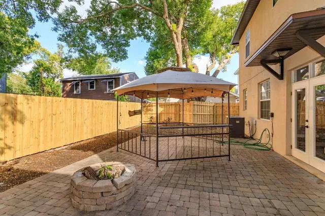 a view of a patio with table and chairs and wooden fence