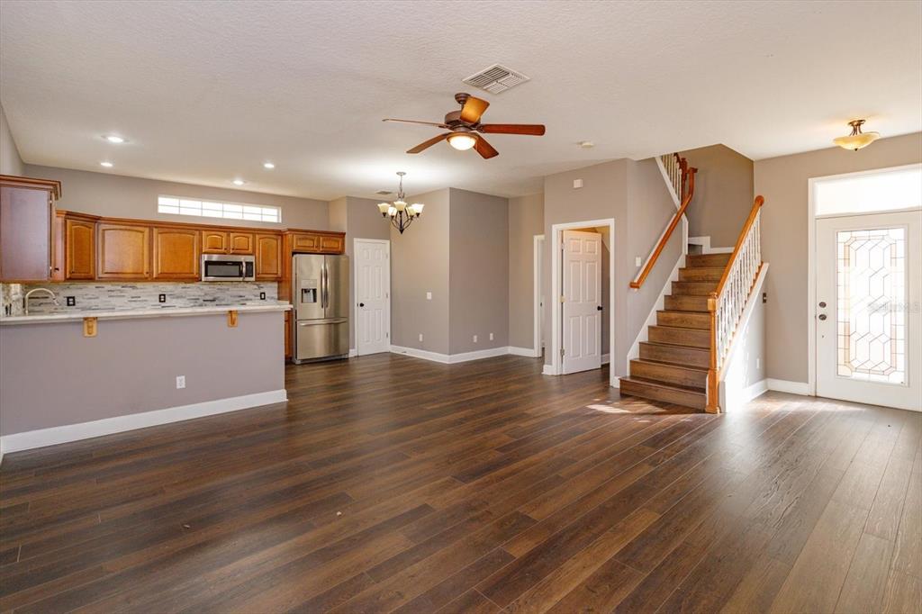 41 East Spruce Street Orlando, FL 32804 - Photo 4 of 24 a view of a kitchen with a refrigerator a ceiling fan and wooden floor