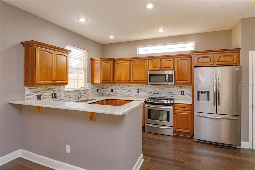 41 East Spruce Street Orlando, FL 32804 - Photo 9 of 24 a kitchen with stainless steel appliances granite countertop a sink stove and refrigerator