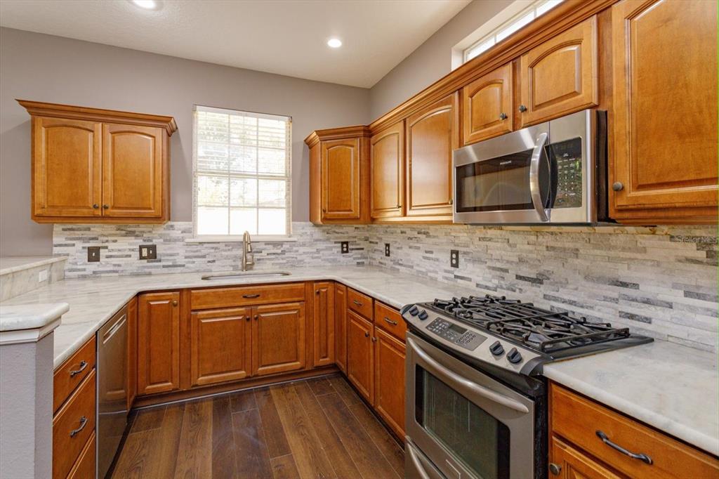 41 East Spruce Street Orlando, FL 32804 - Photo 10 of 24 a kitchen with stainless steel appliances granite countertop a stove and a sink