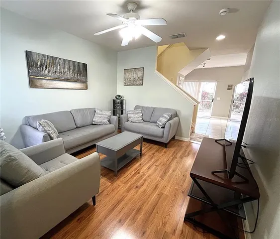 a living room with furniture and wooden floor