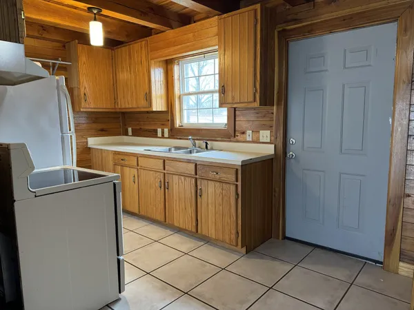 a kitchen with a sink a refrigerator and cabinets