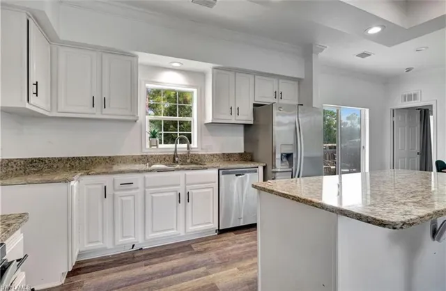 a kitchen with granite countertop a sink stove and refrigerator