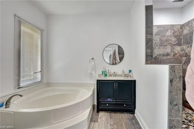 a bathroom with a tub and a chair