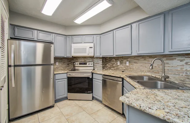 a kitchen with stainless steel appliances granite countertop a refrigerator sink and cabinets