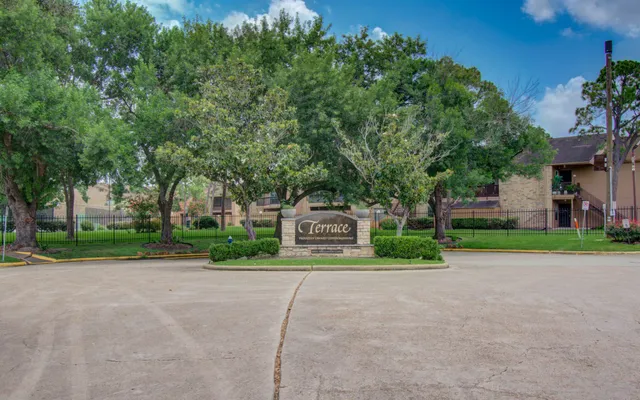 a view of a house with a big yard and large trees