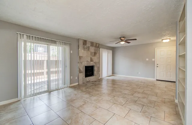 a view of an empty room with a fireplace and a window