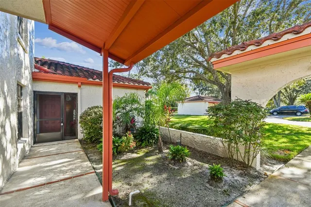 a view of a patio with table and chairs potted plants and floor to ceiling window