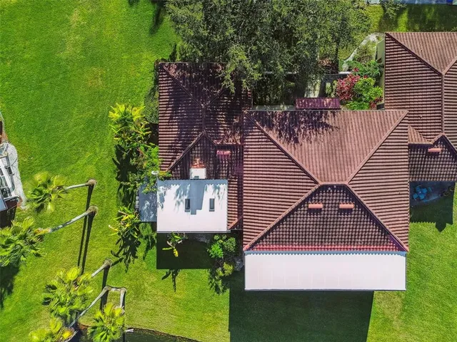 an aerial view of residential houses with outdoor space and trees