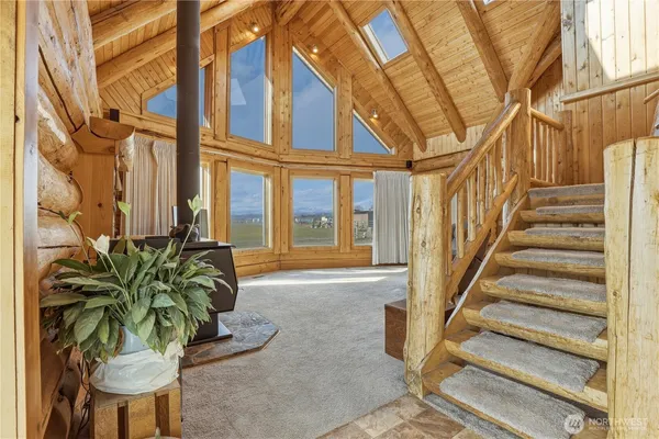 a living room filled with furniture and large windows