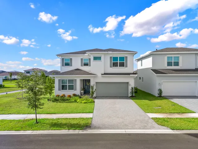a front view of a house with a garden and yard