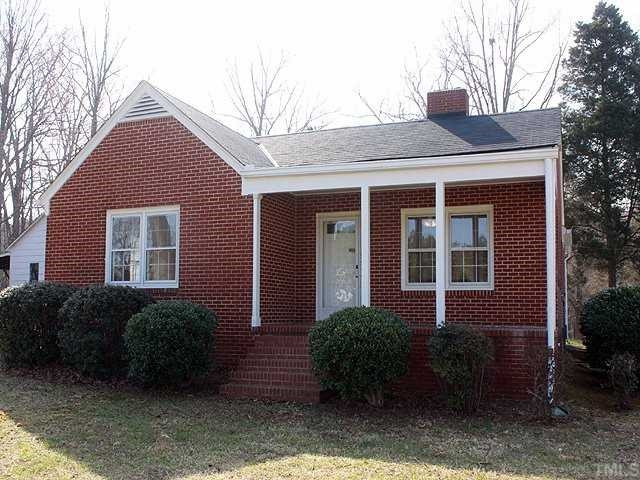 9923 North Roxboro Road Bahama, NC 27503 - Photo 1 of 12 a front view of a house with garden