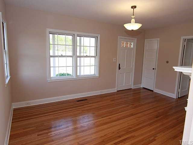 9923 North Roxboro Road Bahama, NC 27503 - Photo 3 of 12 an empty room with wooden floor and windows