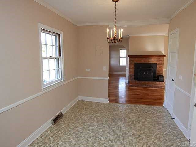 9923 North Roxboro Road Bahama, NC 27503 - Photo 5 of 12 a view of a livingroom with a chandelier fireplace and windows