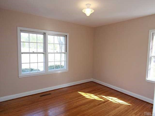 9923 North Roxboro Road Bahama, NC 27503 - Photo 8 of 12 an empty room with wooden floor and windows