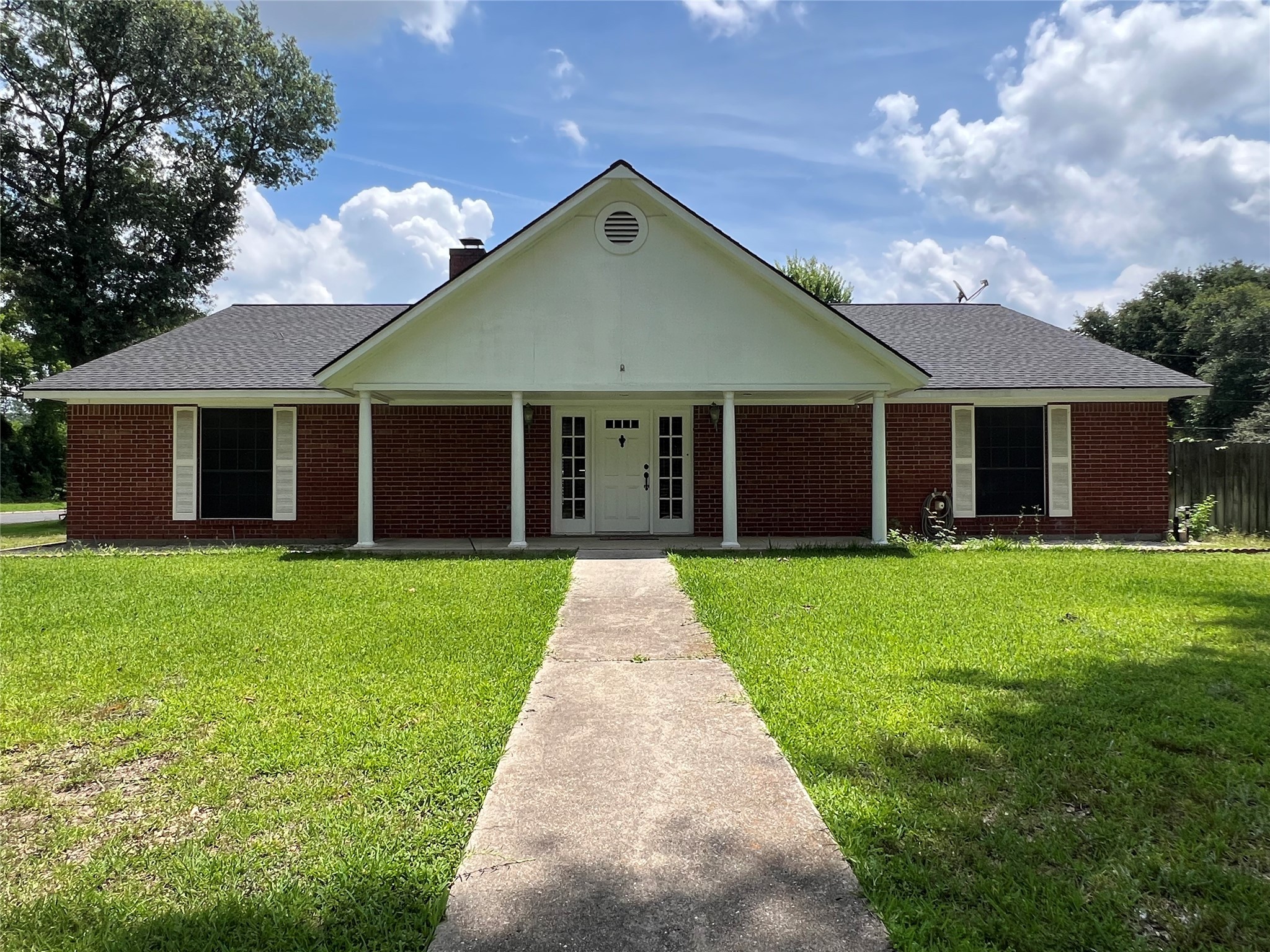a front view of a house with a garden and yard