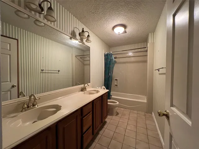 a bathroom with a double vanity sink toilet mirror and shower
