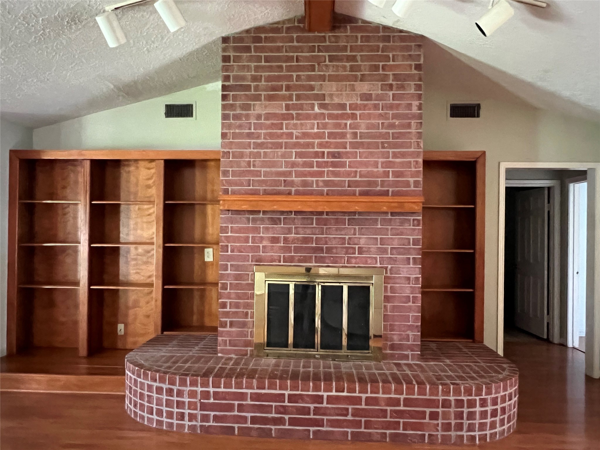 101 Willowbend Street Huntsville, TX 77320 - Photo 4 of 15 a view of empty room with wooden floor and fireplace