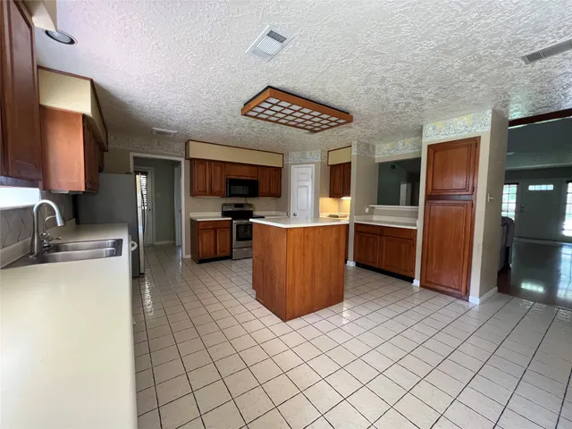 a kitchen with stainless steel appliances granite countertop a refrigerator and a stove