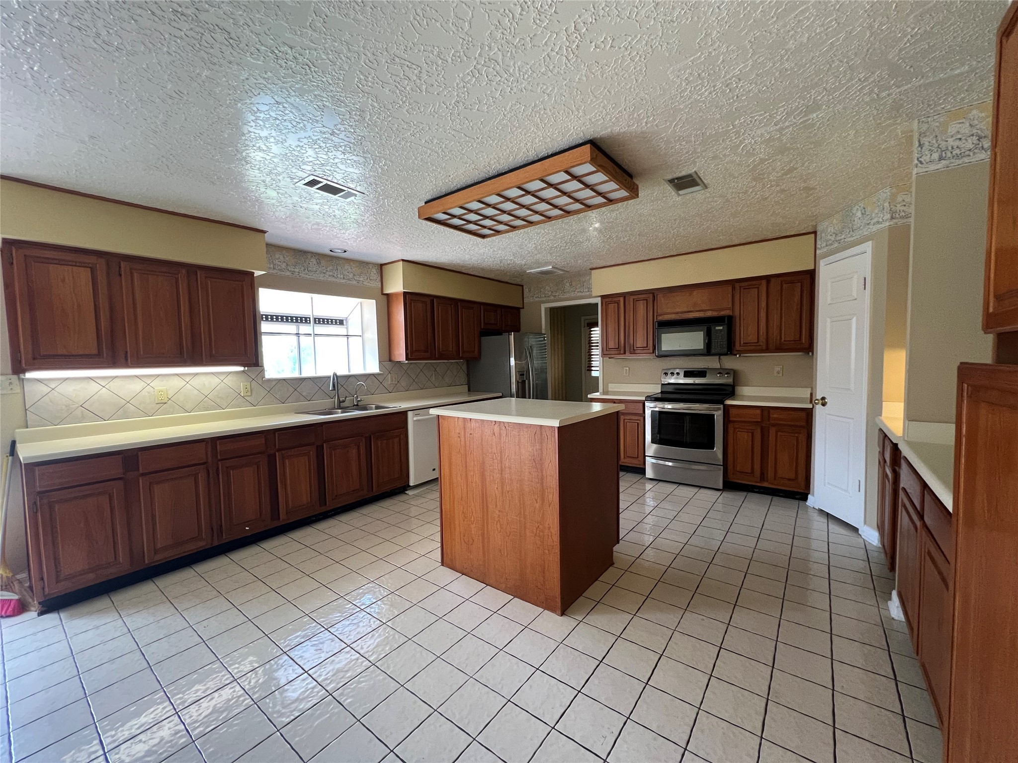 101 Willowbend Street Huntsville, TX 77320 - Photo 9 of 15 a kitchen with stainless steel appliances kitchen island granite countertop a stove cabinets and sink