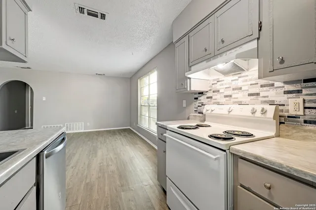 a kitchen with granite countertop a stove and a sink