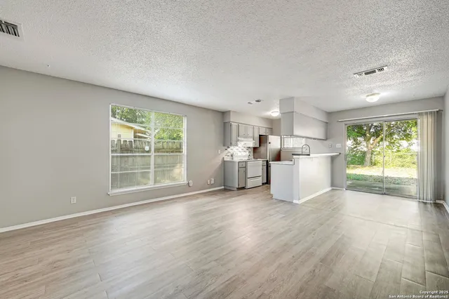 a view of a kitchen with furniture and wooden floor