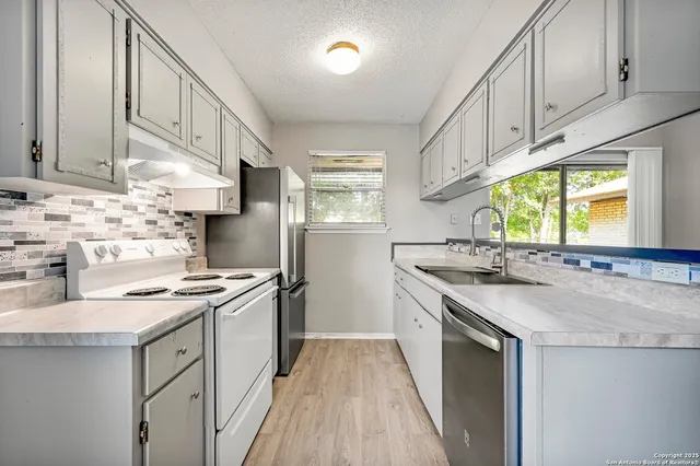 a kitchen with stainless steel appliances granite countertop a sink stove and cabinets