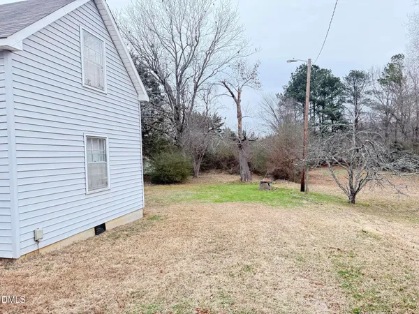 a view of a dry yard covered with snow in front of house