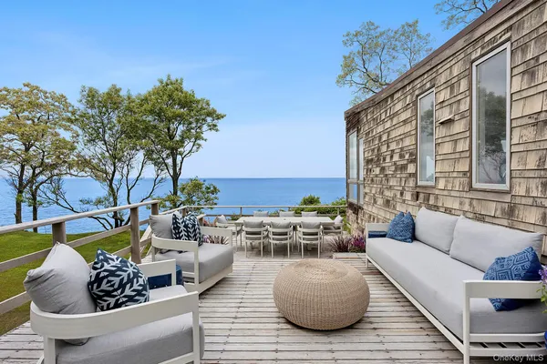 a view of a roof deck with table and chairs and potted plants