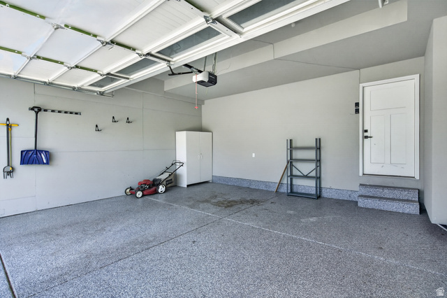 36 West Syracuse Road Vineyard, UT 84059 - Photo 48 of 56 Spacious garage featuring a durable epoxy-coated floor, automatic garage door opener, and a side entry door with integrated steps