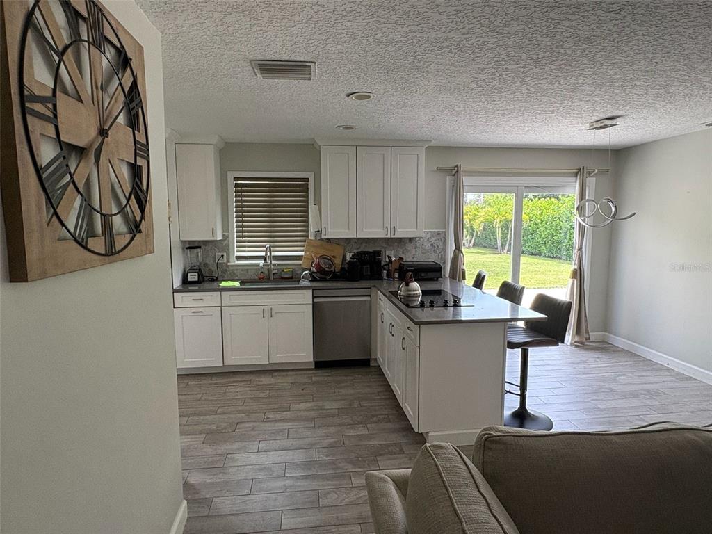125 Southeast 6th Avenue Boynton Beach, FL 33435 - Photo 13 of 27 a kitchen with granite countertop a stove a sink and a microwave