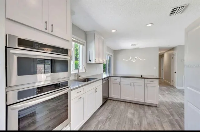 a kitchen with stainless steel appliances granite countertop a stove and a microwave