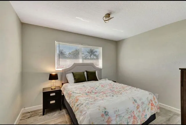 a bedroom with a bed and a night stand