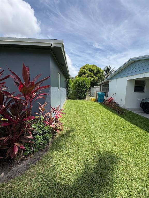 125 Southeast 6th Avenue Boynton Beach, FL 33435 - Photo 6 of 27 a backyard of a house with table and chairs plants and large tree