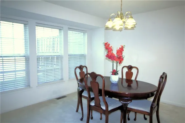 a view of a dining room with furniture and chandelier