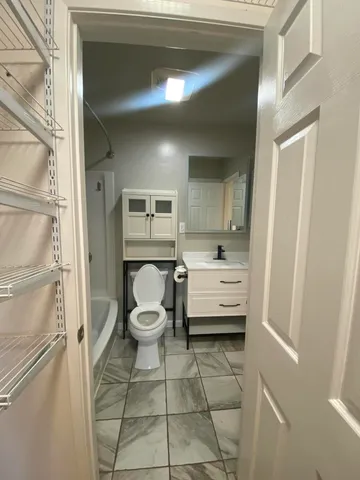 a bathroom with a toilet sink and a mirror