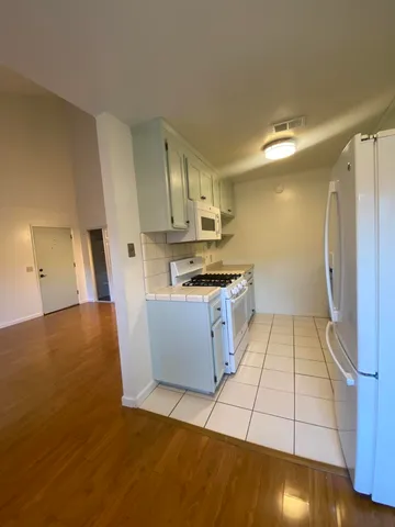 a kitchen with wooden cabinets and white appliances