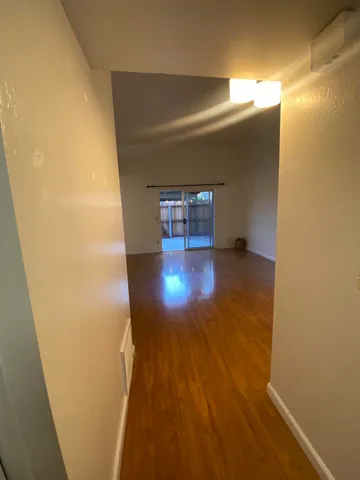 a view of an empty room with wooden floor