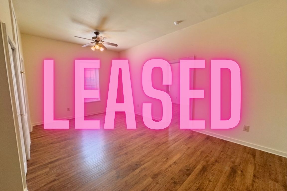 a view of a room with wooden floor and a ceiling fan