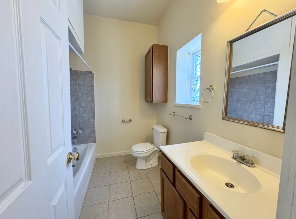 104 Depot Street, Unit B Elgin, TX 78621 - Photo 11 of 15 Full bathroom with vanity, tile patterned flooring, toilet, washtub / shower combination, and baseboards