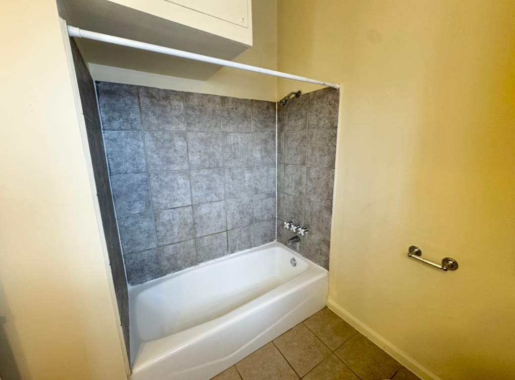 104 Depot Street, Unit B Elgin, TX 78621 - Photo 12 of 15 Bathroom featuring tile patterned floors, baseboards, and shower / tub combination