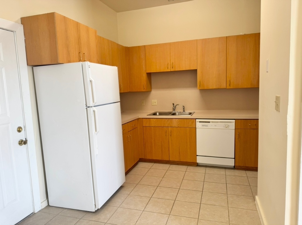 104 Depot Street, Unit B Elgin, TX 78621 - Photo 5 of 15 Kitchen featuring white appliances, a sink, light countertops, and light tile patterned flooring