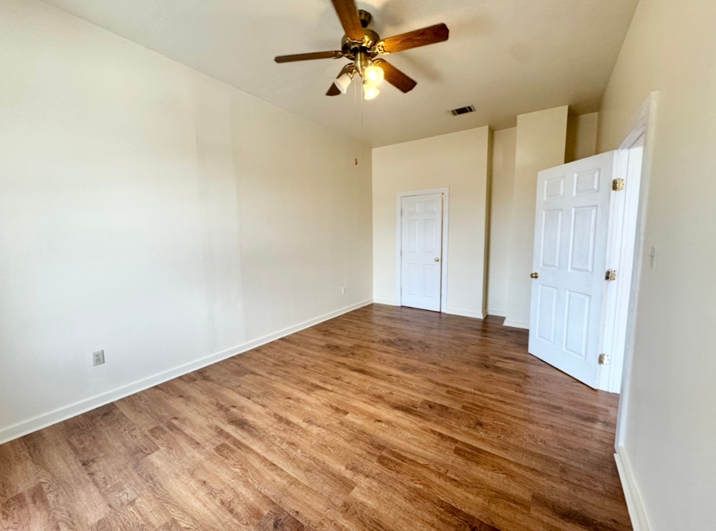 104 Depot Street, Unit B Elgin, TX 78621 - Photo 7 of 15 Unfurnished bedroom with wood finished floors, baseboards, and a ceiling fan